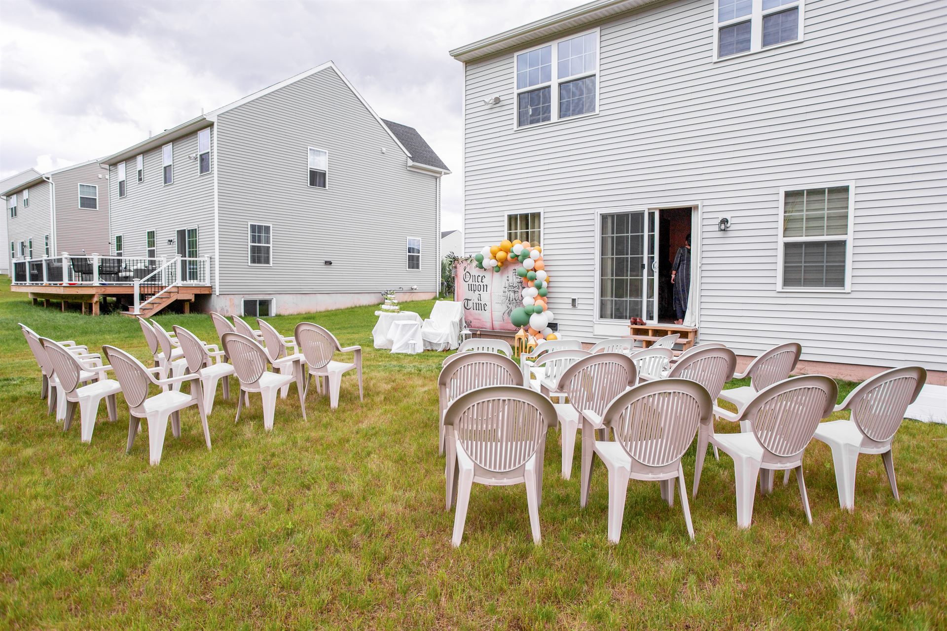 Backyard baby shower with rows of guest seating facing the storybook backdrop